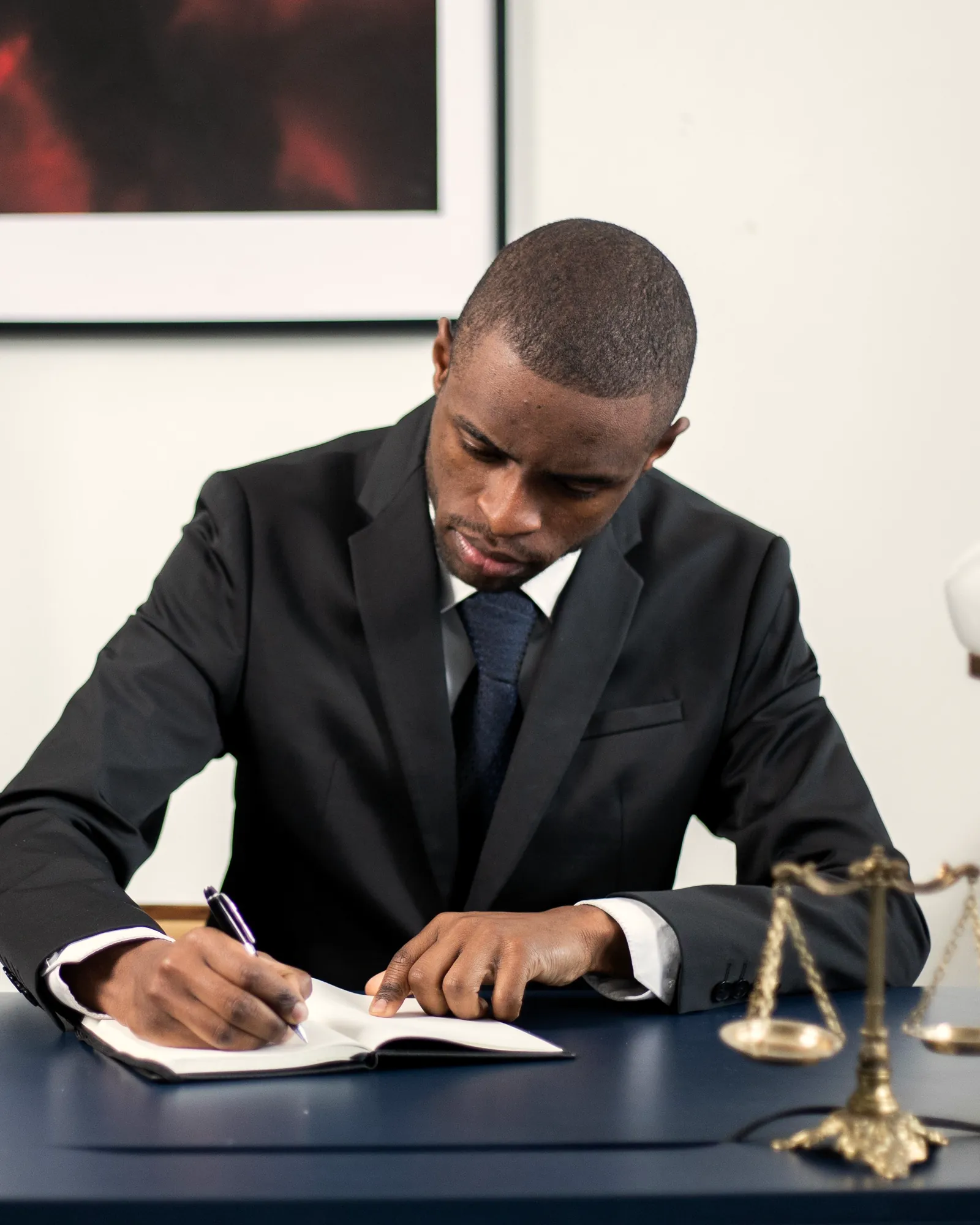 Lawyer writing notes at his desk in a law office